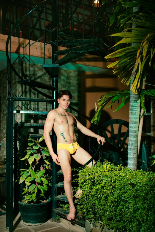 a shirtless man posing in a yellow briefs