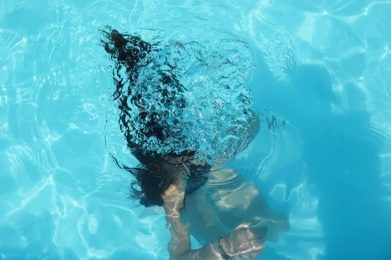 woman under water swimming in blue swimming pool