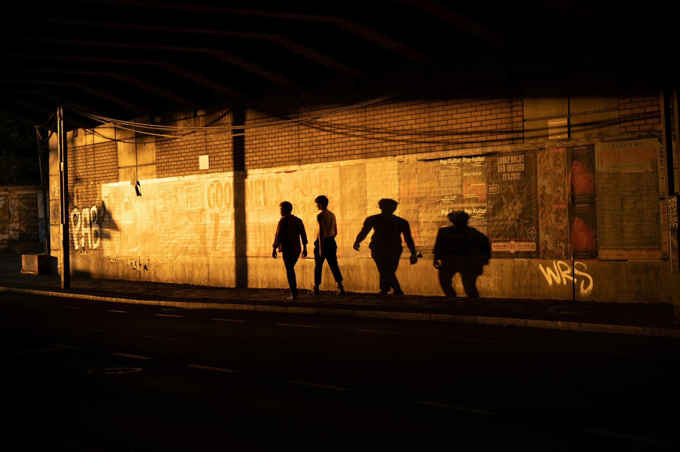 a group of young people walking along side of a building