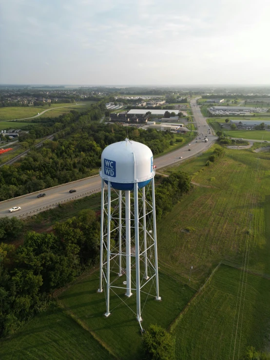 the blue and white water tower is high above the road