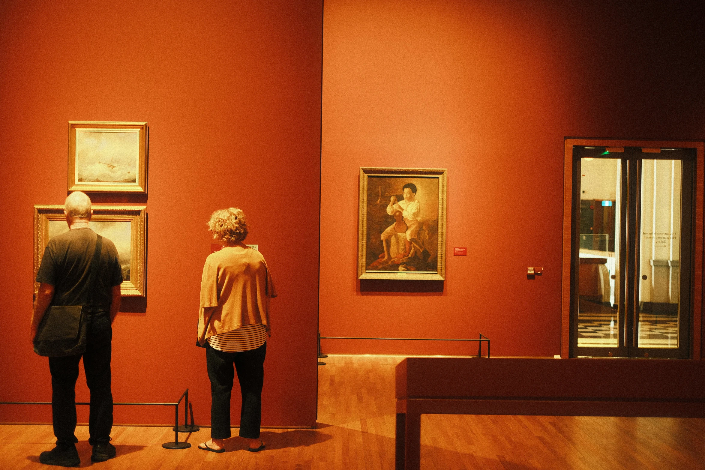 a couple of people looking at some art in a museum