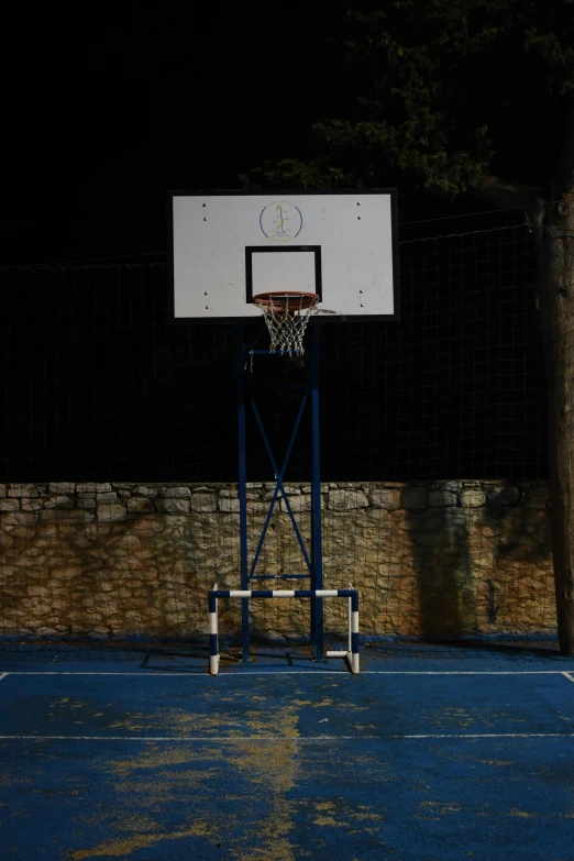 a basketball player standing on a basketball court in the dark