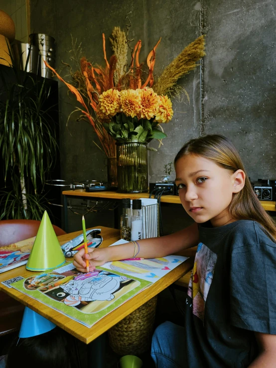 a  sitting at a table with some markers