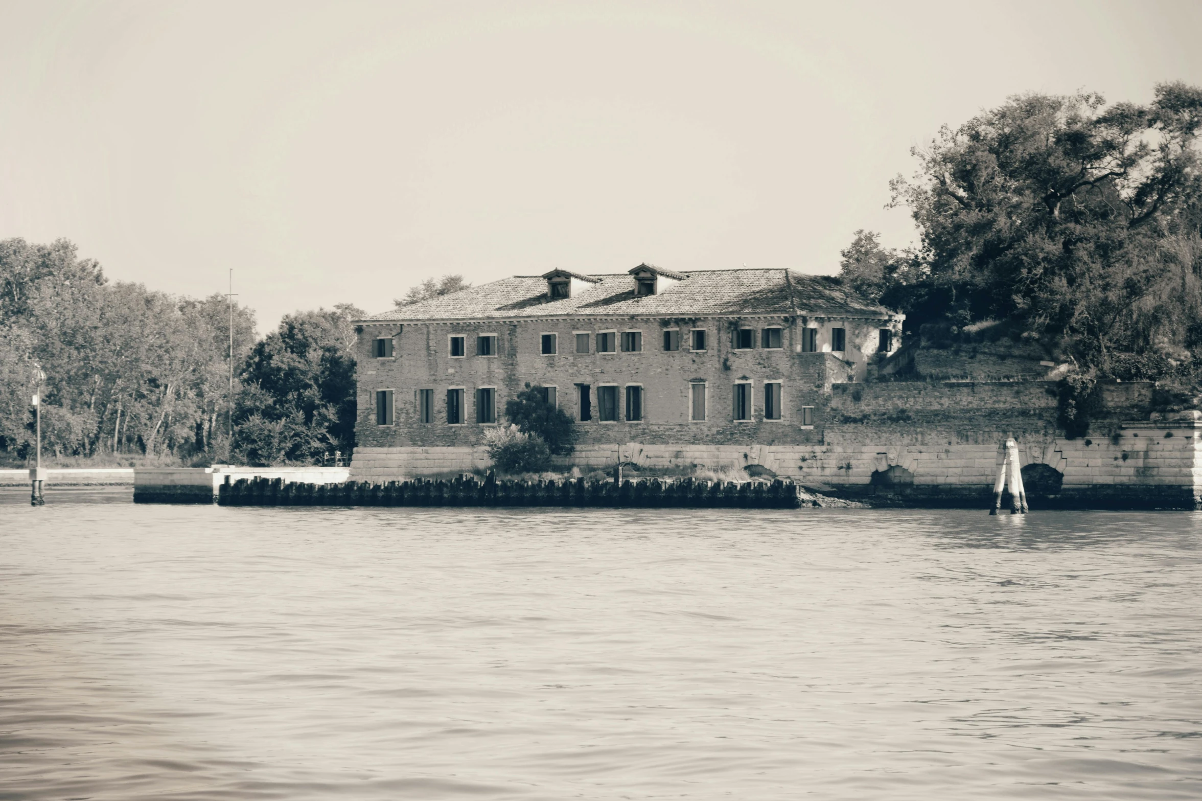 a house sitting on top of a pier next to a river