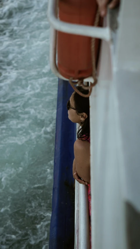 a woman sitting on the back of a boat in a river