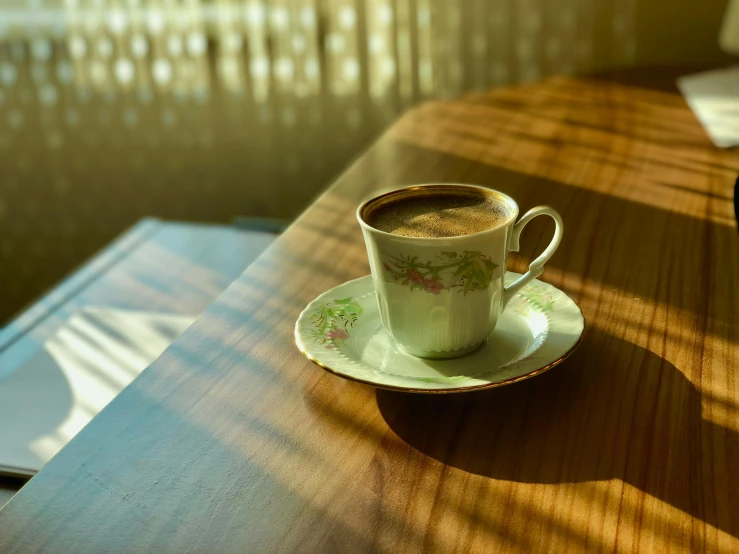 a cup of coffee sitting on top of a wooden table