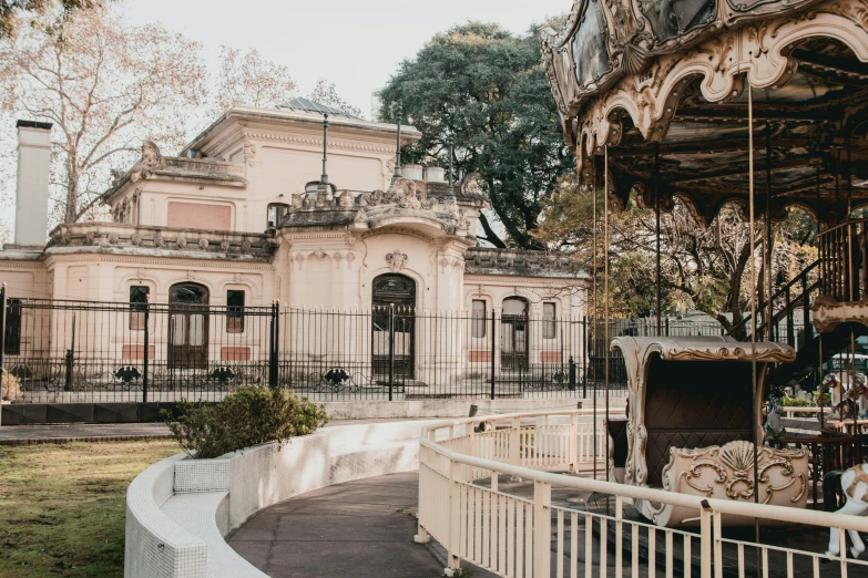 a po of a carousel in front of a pink building