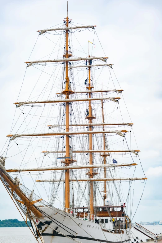 the tall sail boat is sailing across the water