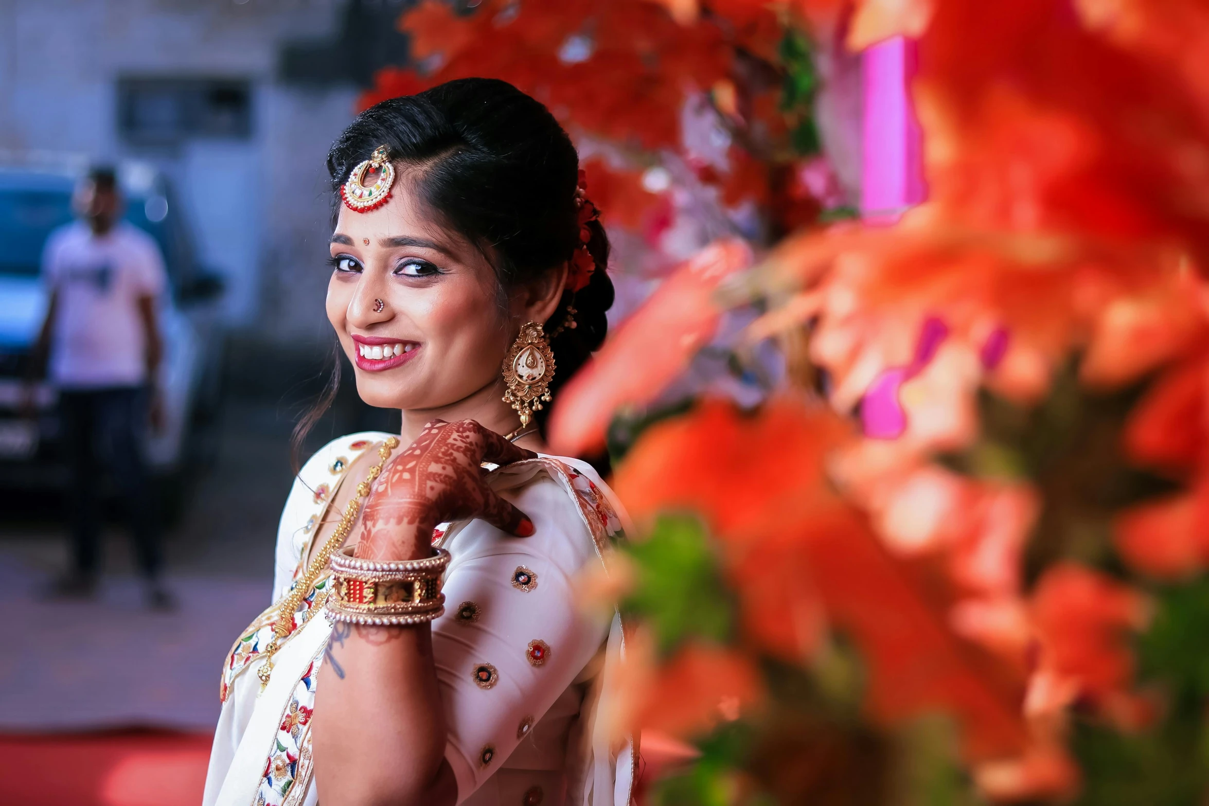 an indian woman is wearing gold jewelry and standing outside