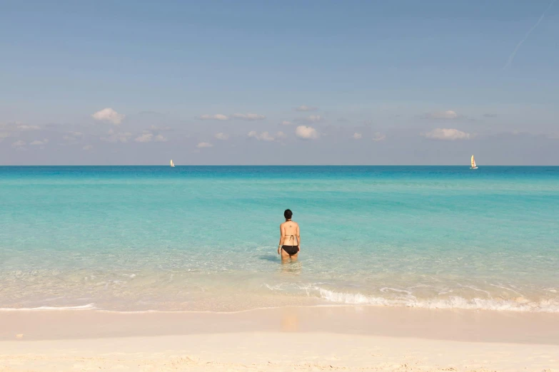 a man standing in the ocean surrounded by clear blue water