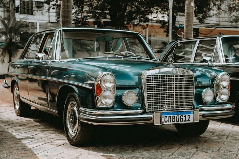 there are two old style cars that are parked on the side of the road