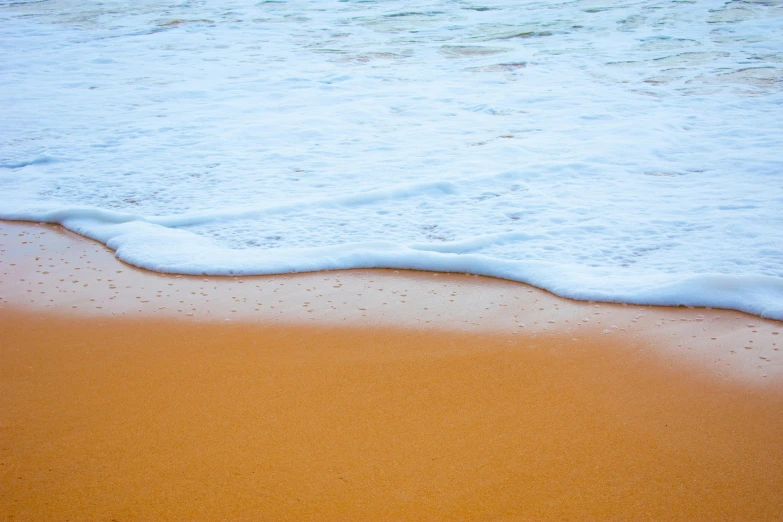 ocean waves in the sand with water on it