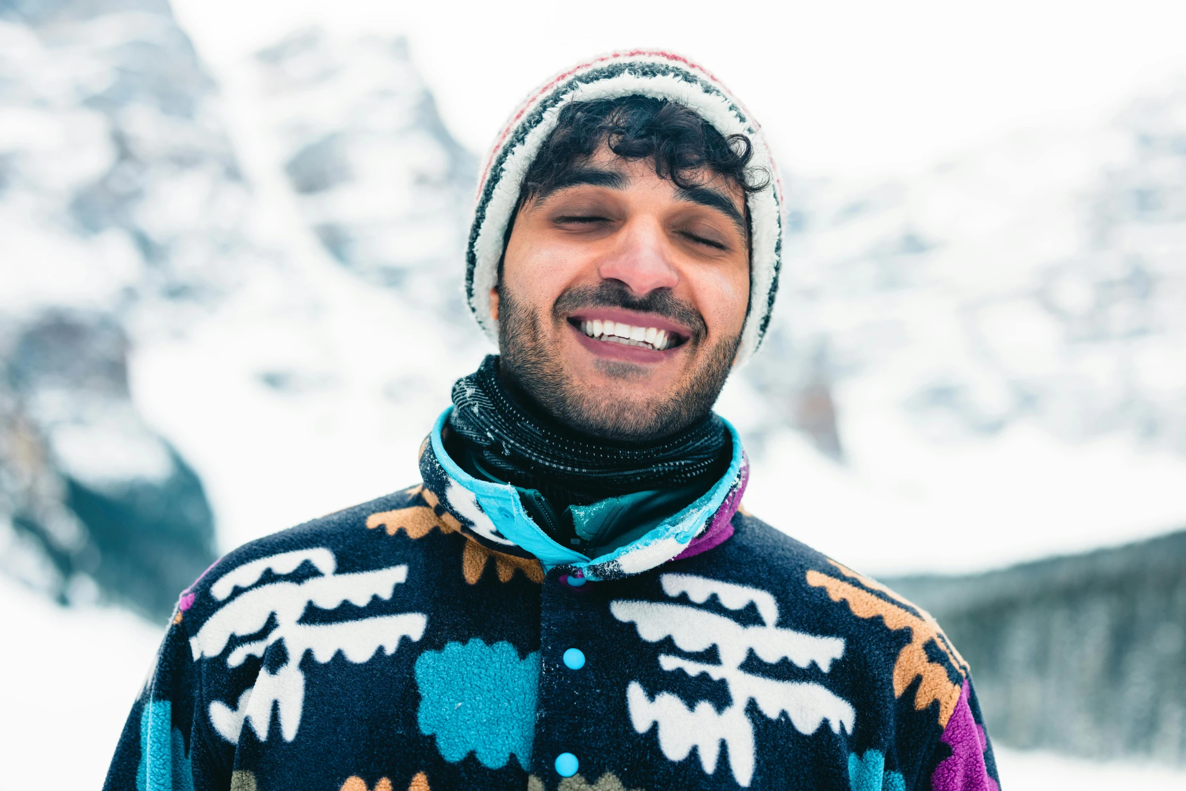 a man smiling outside in a ski sweater