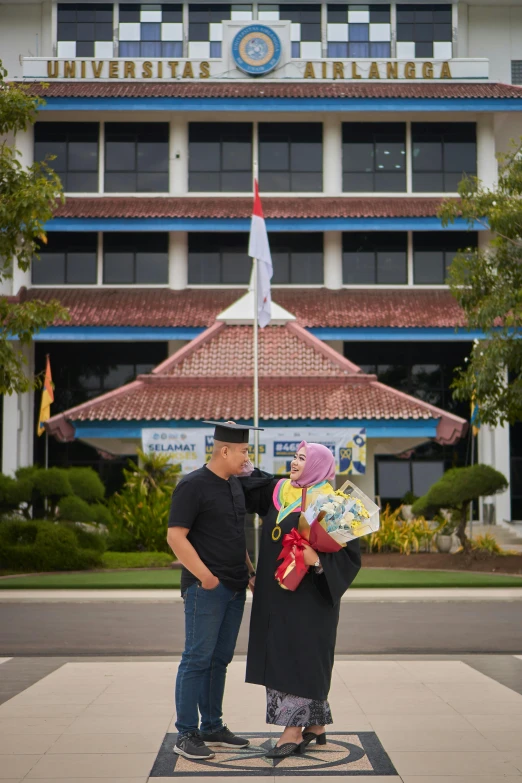 two people standing on the front porch of a large building