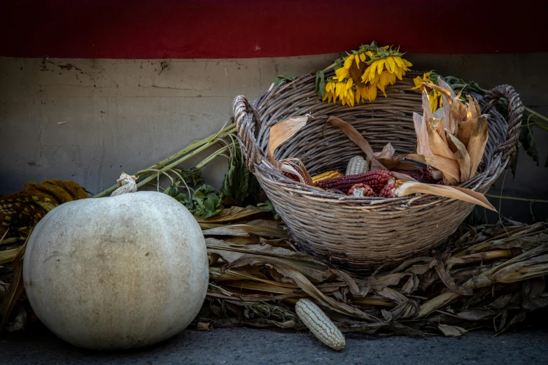 a pumpkin sits in a basket and sunflowers sit around it