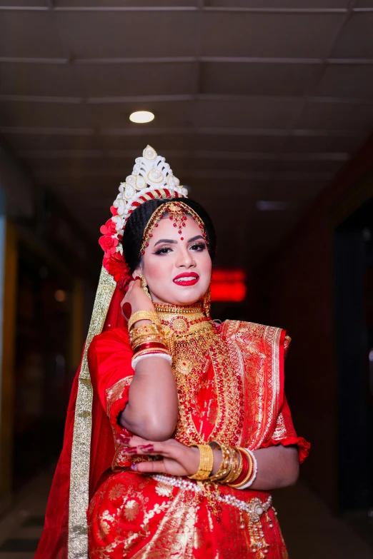 a woman in traditional indian dress standing with her hands on her chest