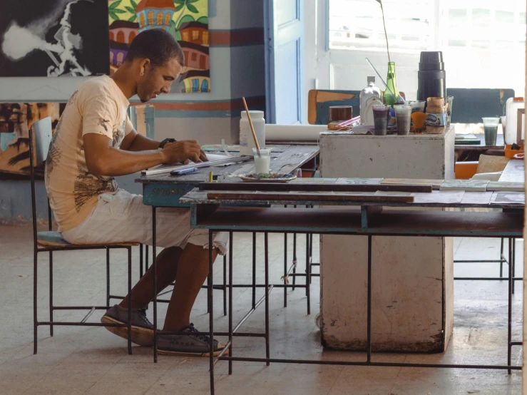 a man sitting at a desk while writing on a book