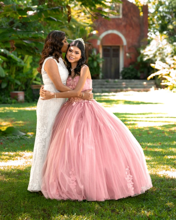 two beautiful women in wedding dresses on the grass