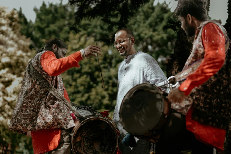 an old man is showing another man how to play drums