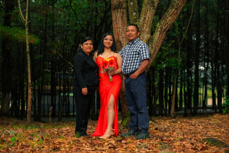 a woman in a red dress and two men standing beside her