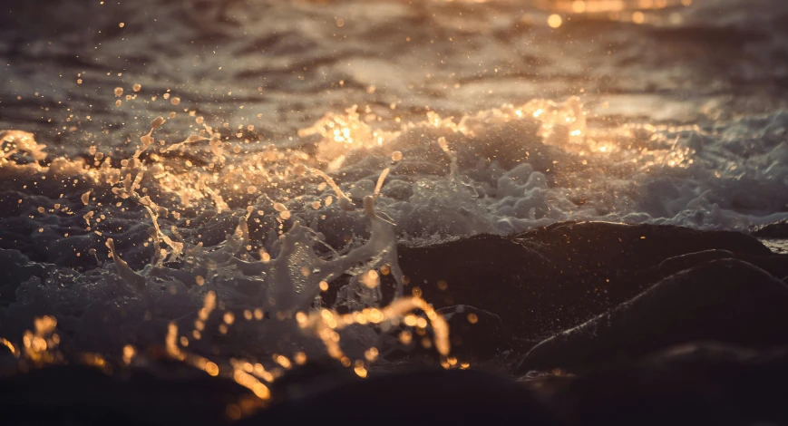 close up picture of ocean waves with sun glaring through