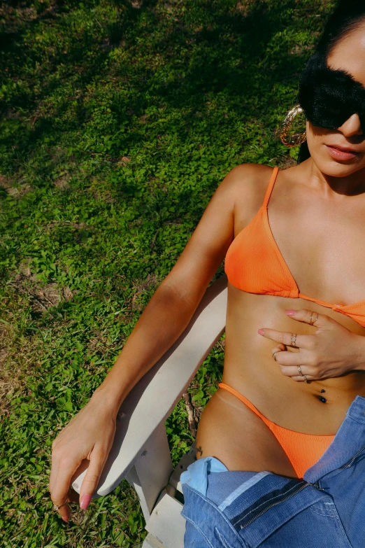 a woman with sunglasses sitting in the grass