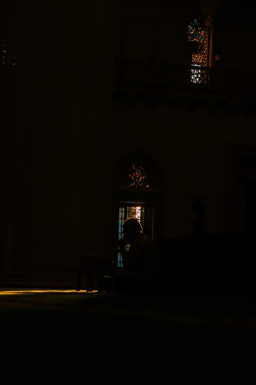 a person in a church at night looking through a window