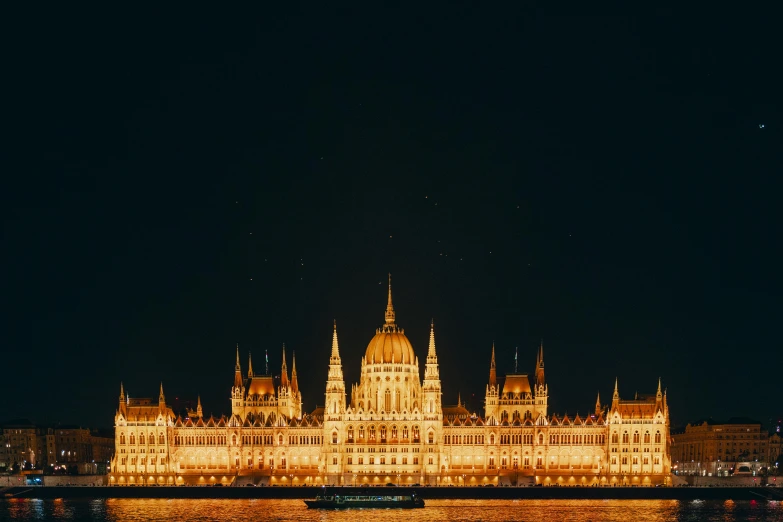 a castle is lit up by lights from a boat at night