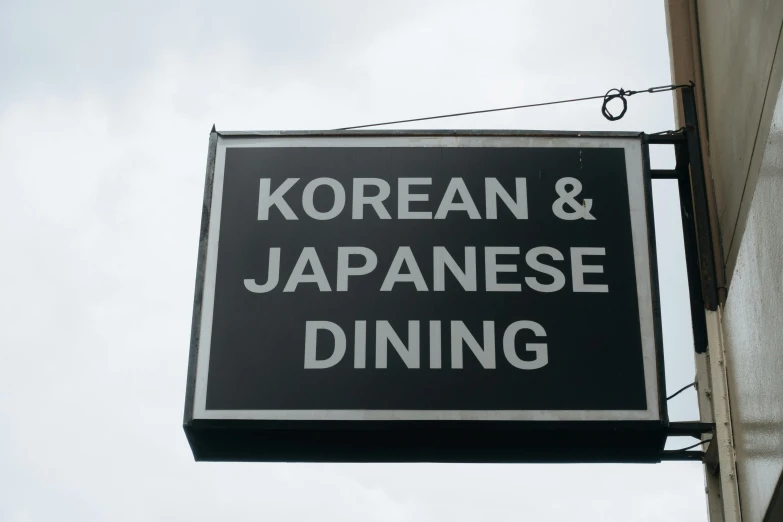 a sign hanging off the side of a building that says korean & japanese dining