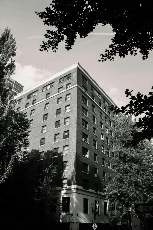 a black and white image of a building near trees