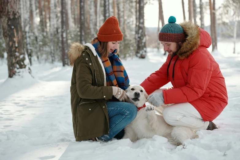 a woman crouches down next to a white dog as she pets it