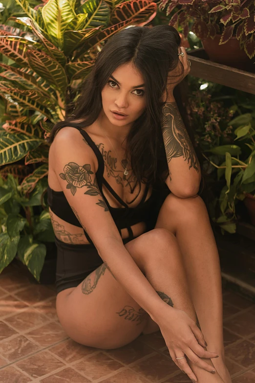 woman in short and black underwear sitting in front of plants