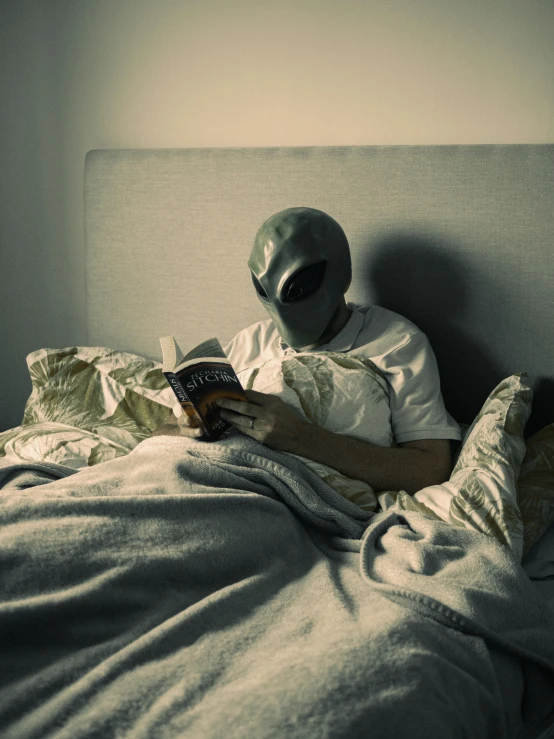 a man wearing a paper mask laying in bed