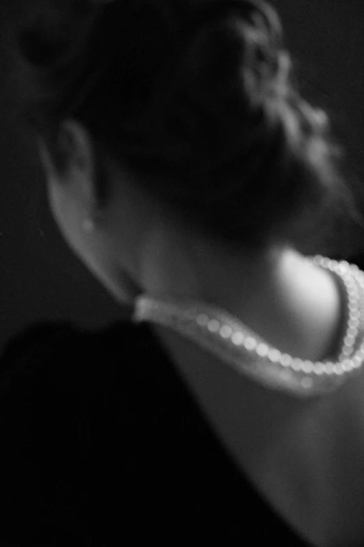 a woman with her hair in a bun and pearls on it