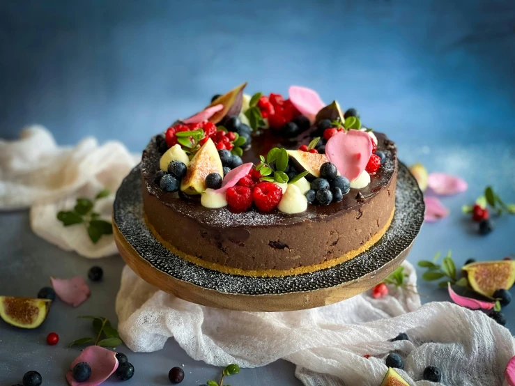 an elaborate fruit and flower decorated chocolate cake