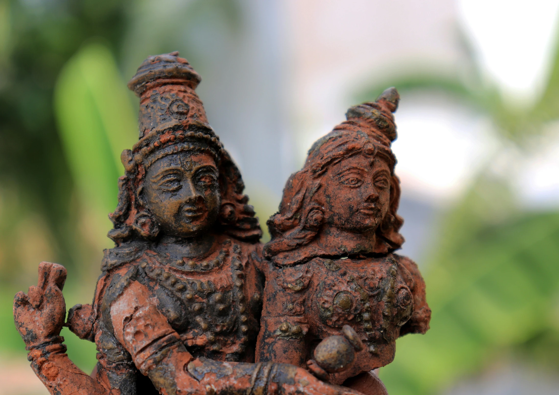 a decorative statue of two deities, one of them holding another one