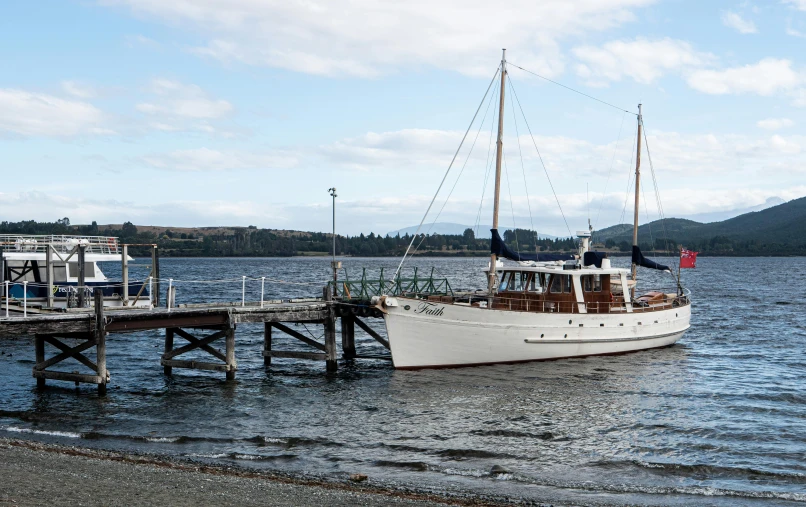 a boat sitting in the water by a pier