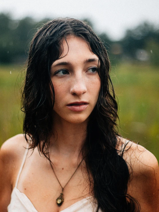 young woman standing in grass and wearing long brown hair with bangs in wet, dd po