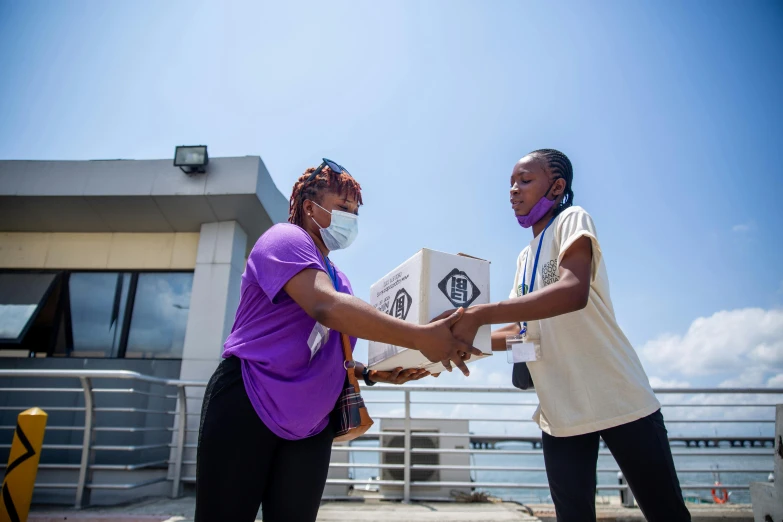 two woman exchanging a package on a ferry