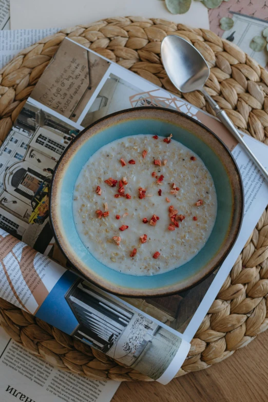 a bowl of porridge sitting on top of a basket next to a spoon