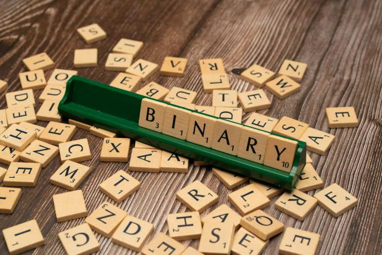 several scrabbles spelling the word binary on top of each other