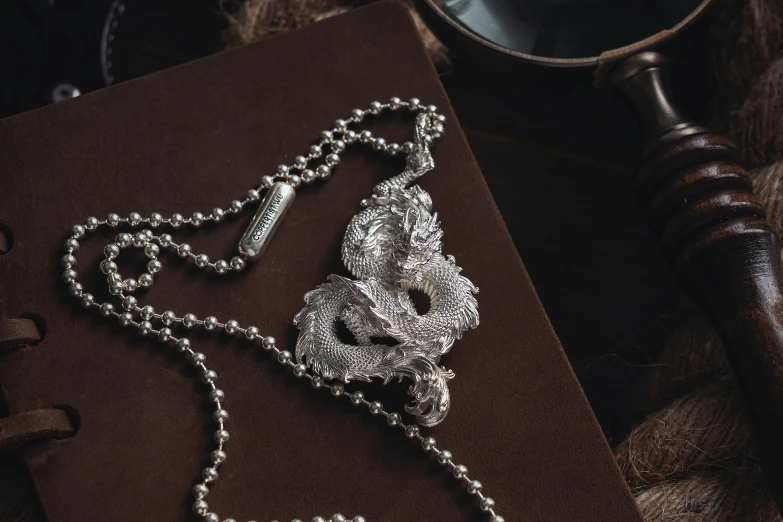 a chain hanging from a book with some beads