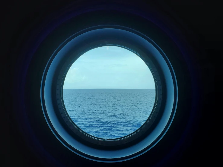 an ocean view through the round window in a building