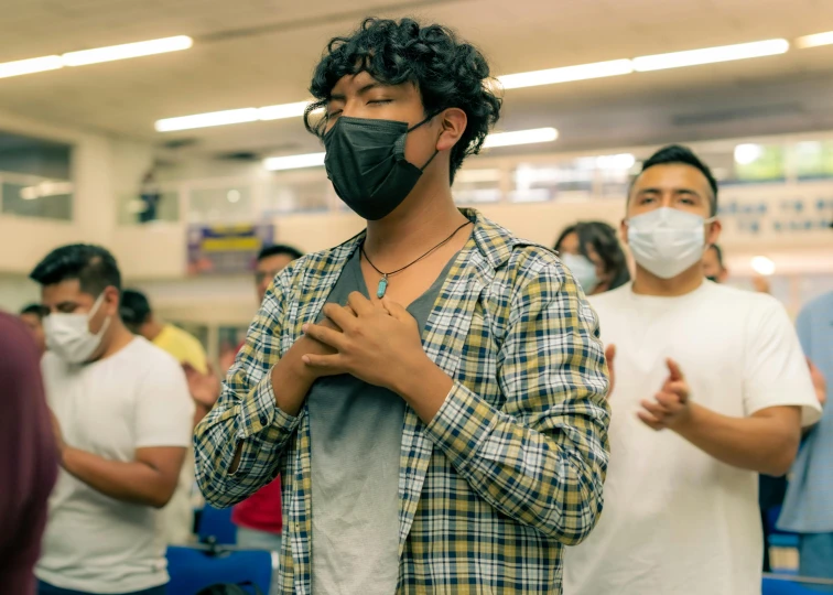 people wearing masks standing around and clapping