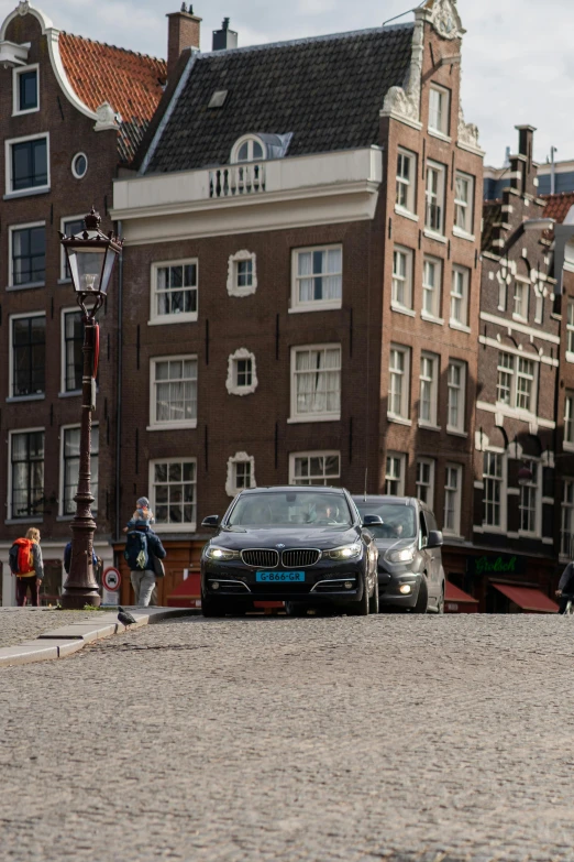 three cars sitting in front of some brown buildings