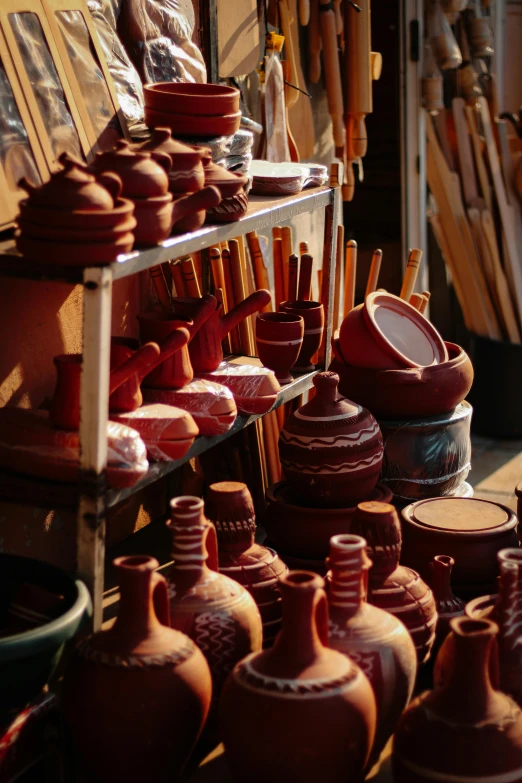 a small shelf filled with pottery in a store