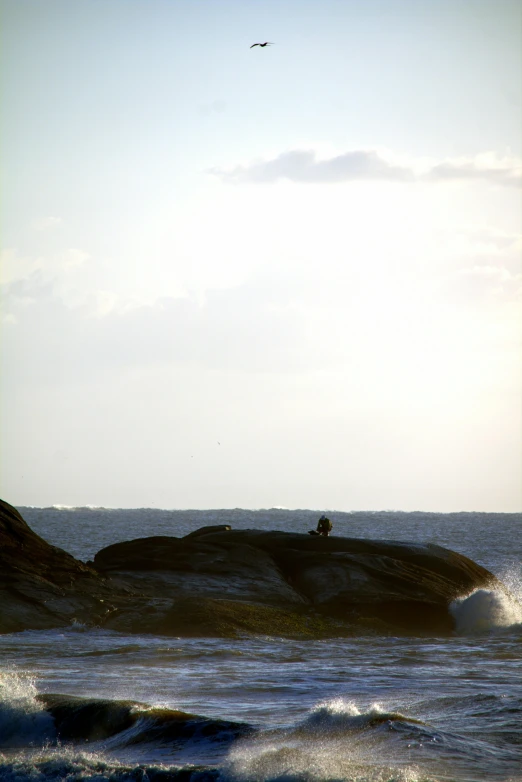 two people on some rocks in the water