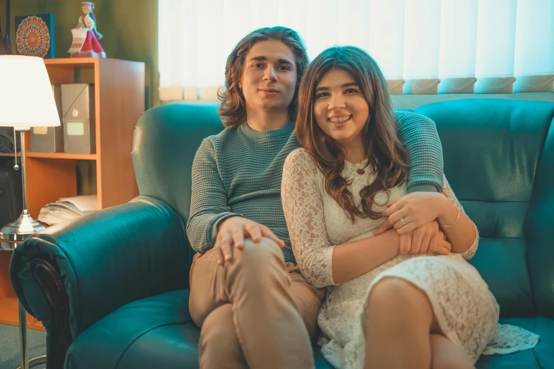 two people are sitting on a couch posing for a po