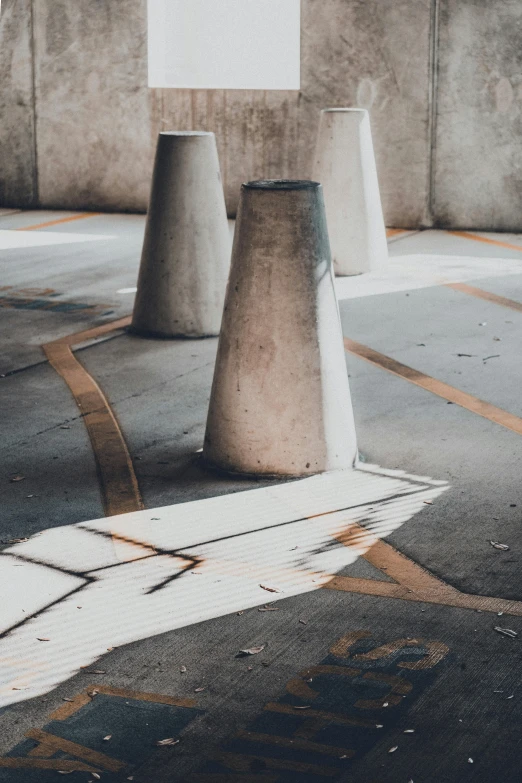 four large grey vases next to each other on the sidewalk