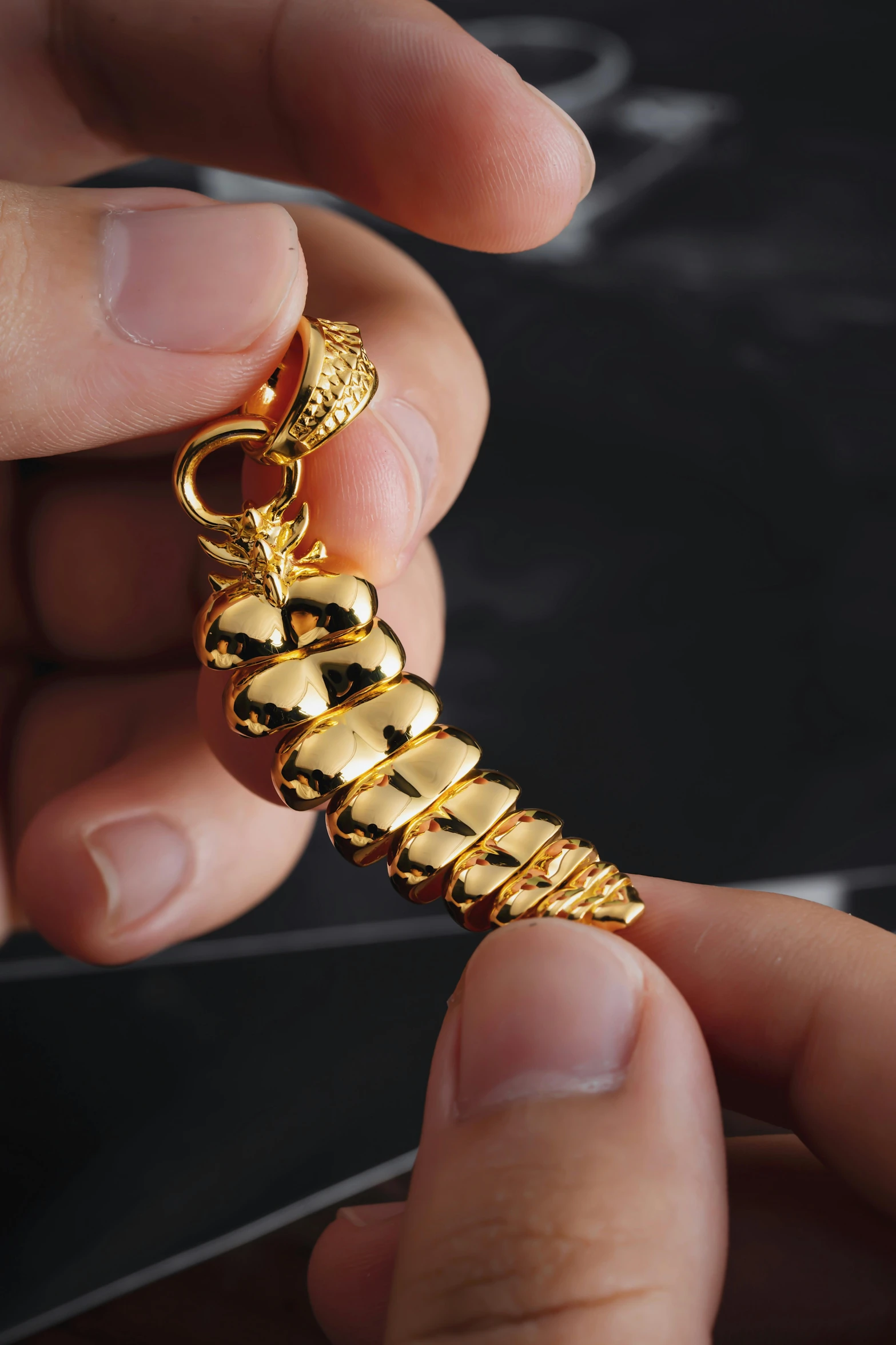 a close up of a person holding a gold chain